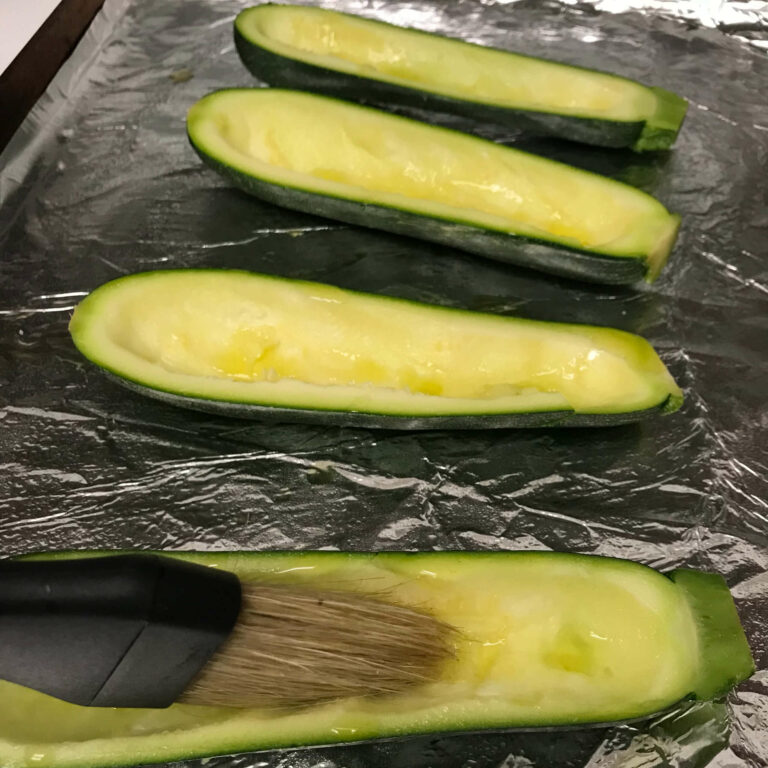 brushing olive oil on zucchini