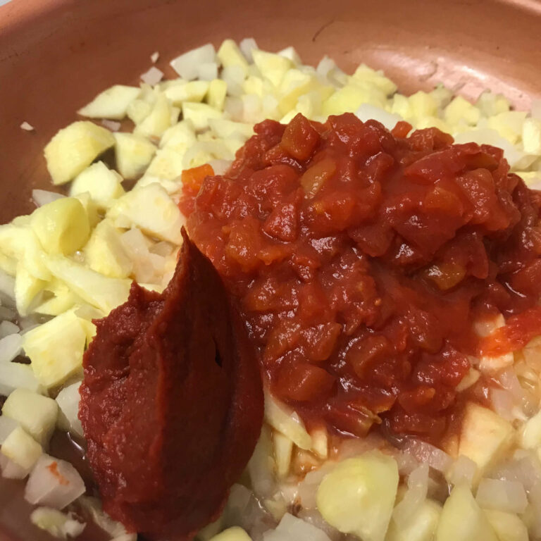 zucchini flesh, onions, tomatoes and tomato paste in a skillet