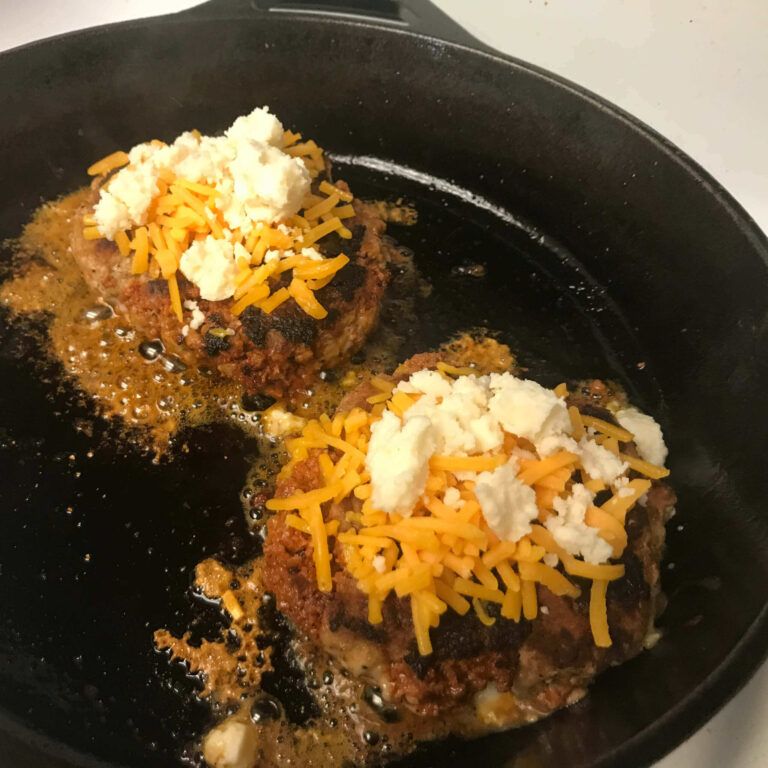 burger patties topped with cheese in a skillet