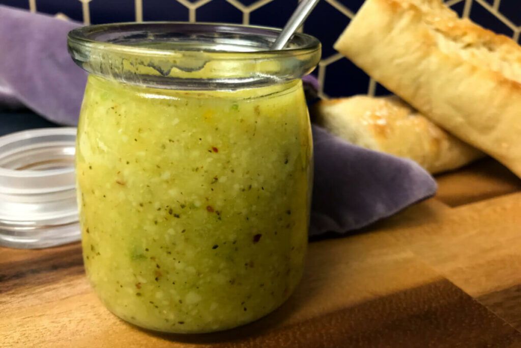 jar of salsa di parmigiano with loaves of bread