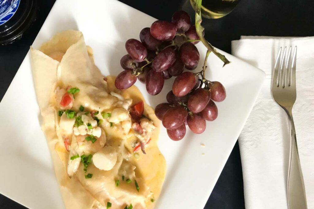 seafood crepes and grapes on a plate