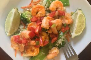 shrimp and veggies on a plate with lime
