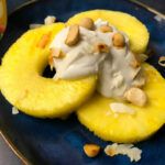 pineapples with coconut cream and nuts on a plate
