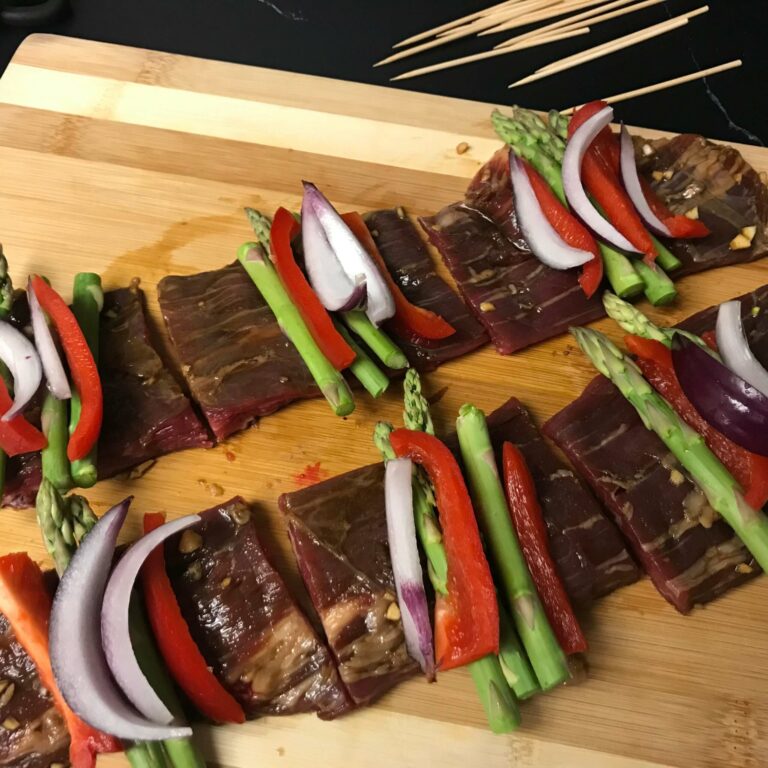 raw marinated beef topped with slices of veggies.