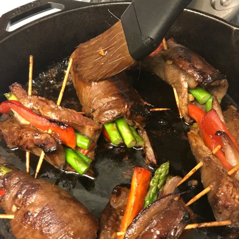 Asian-Beef-Veggie-Rolls in a skillet being basted.