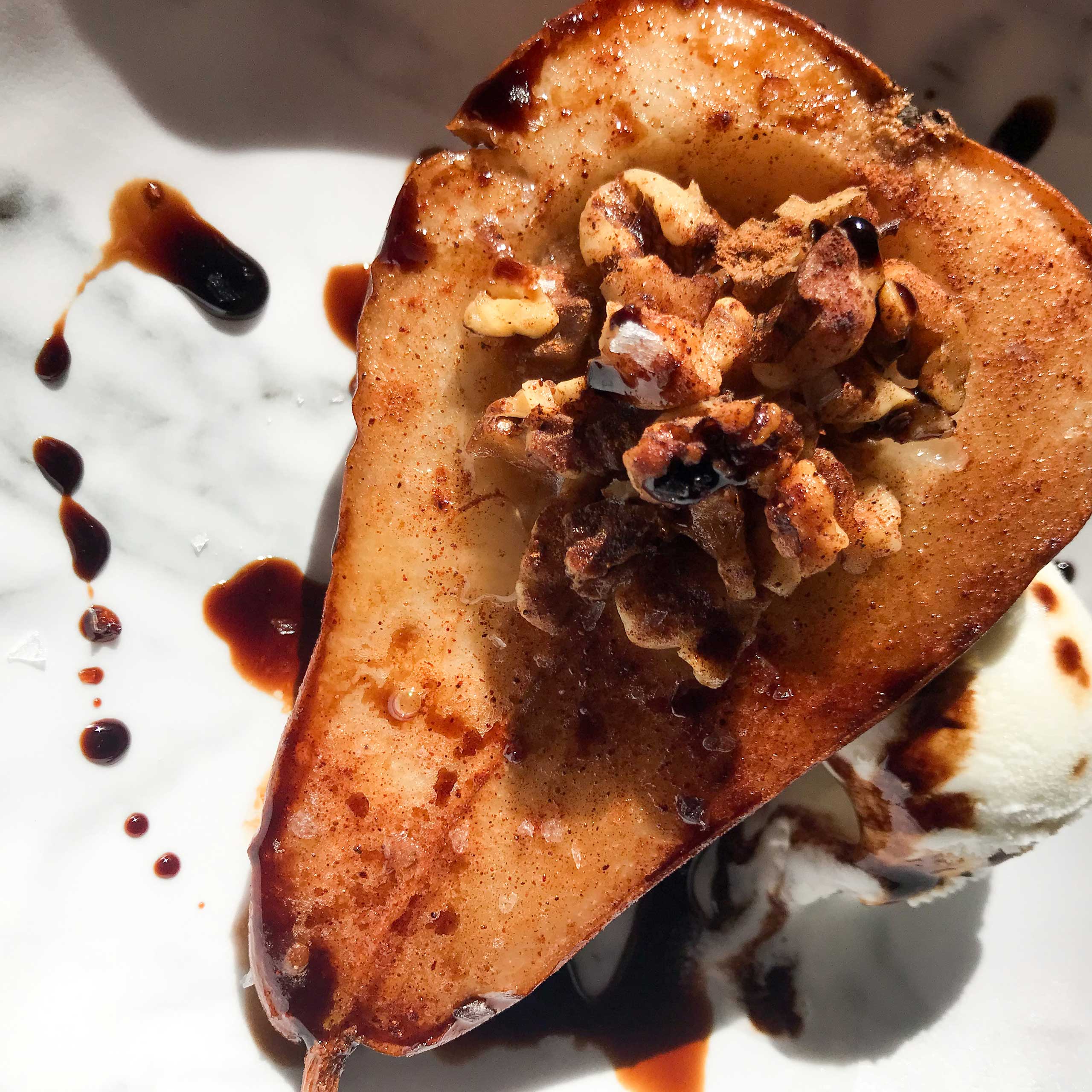 half a pear stuffed with walnuts and drizzled with balsamic vinegar.