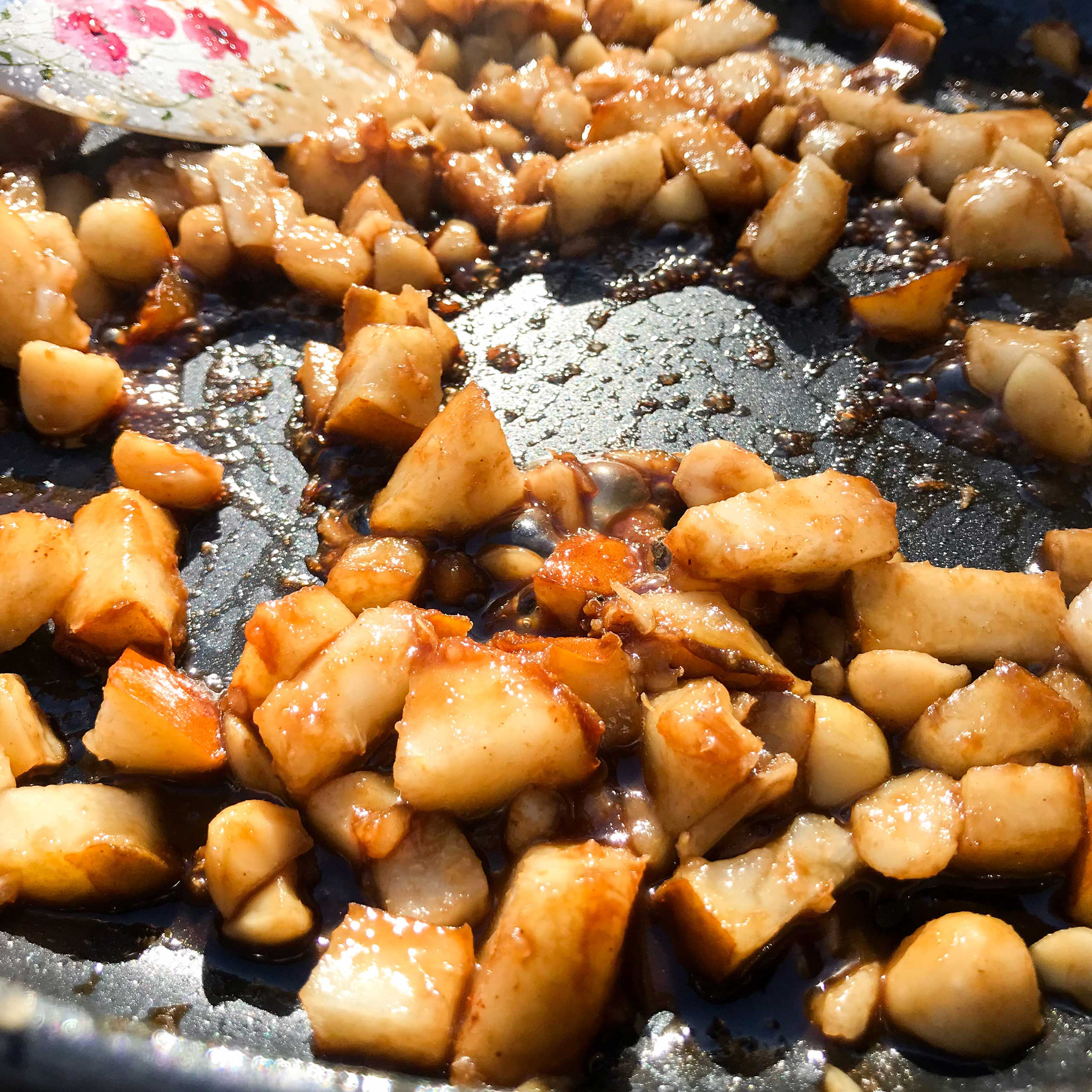pears and macadamia nuts cooking in skillet.