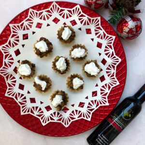 plate of balsamic pear and macadamia nuts topped with whipped cream.