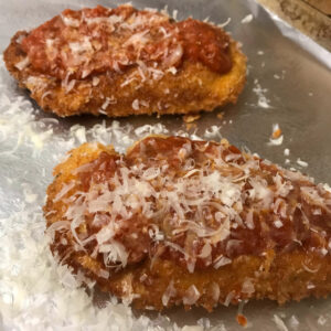 chicken cutlets with sauce and parmesan cheese.