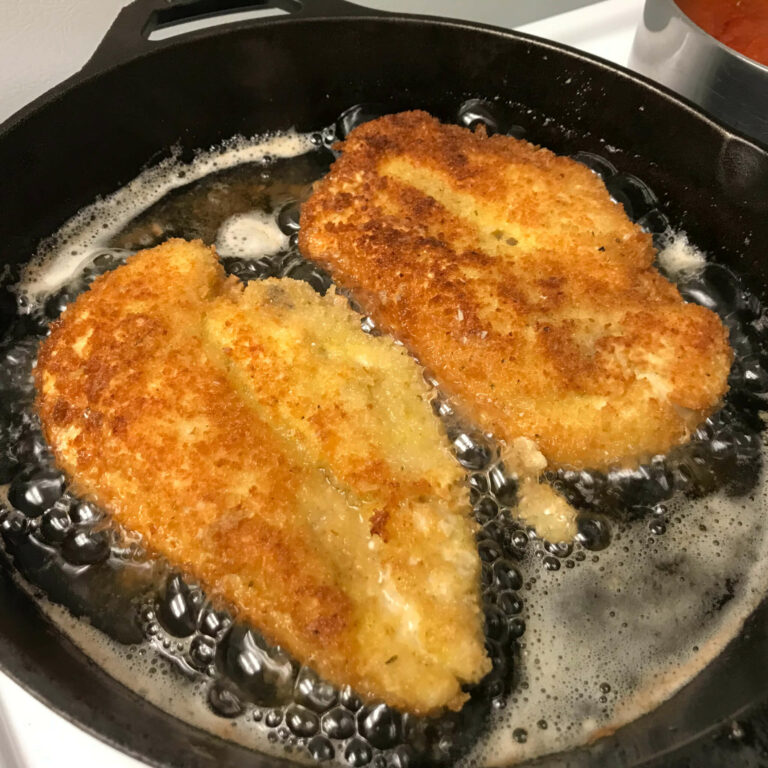 cooked chicken cutlets cooking in skillet.