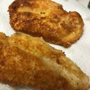 chicken cutlets on paper towel lined plate.