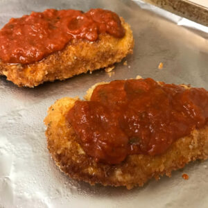 chicken cutlets topped with sauce.