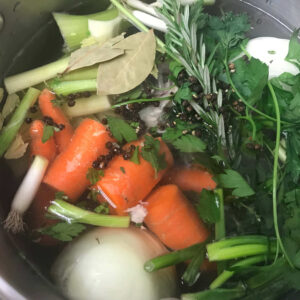 veggies and herbs in a pot.