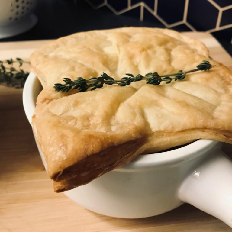 cream of mushroom soup topped with puff pastry and a thyme sprig.