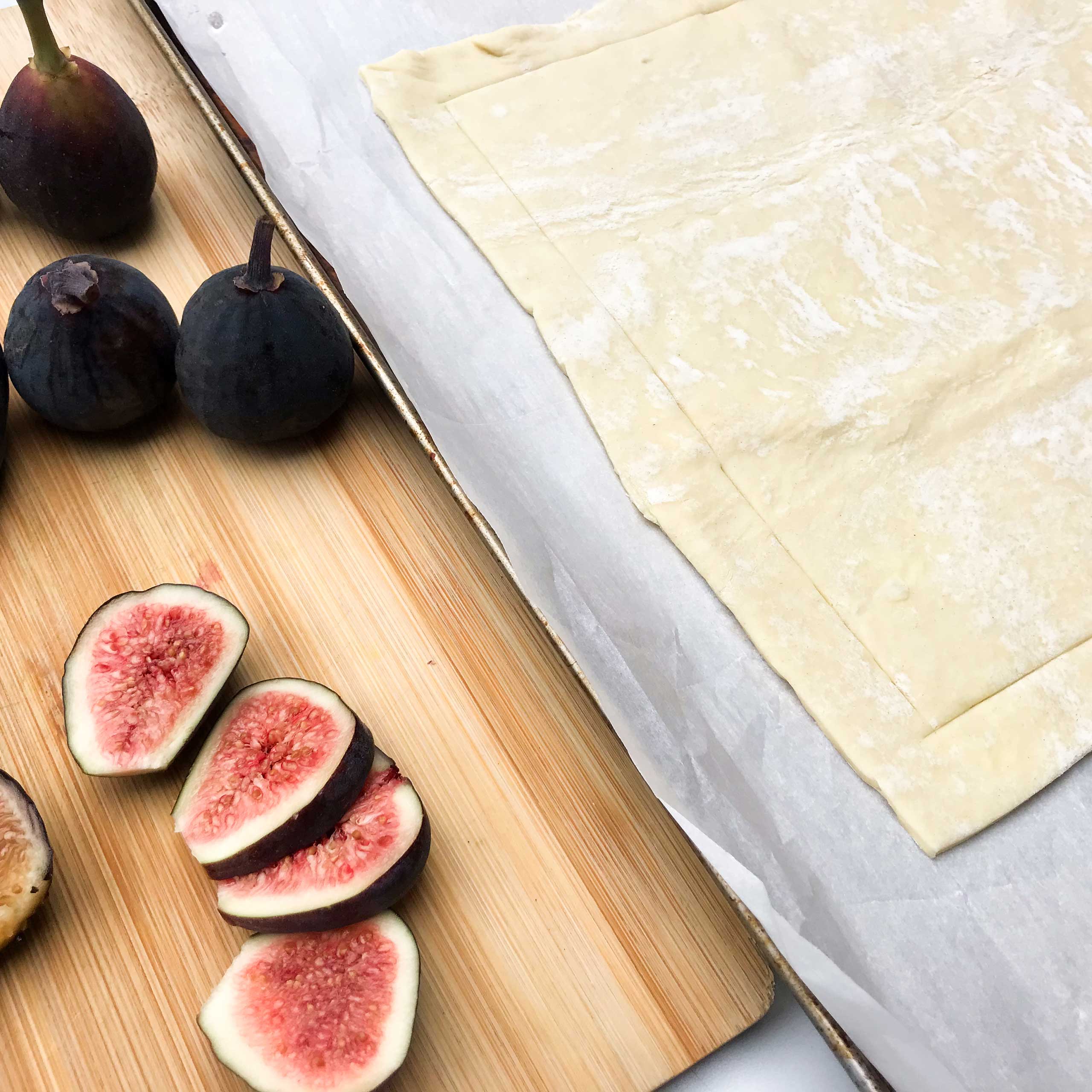 rolled out dough next to cut figs.