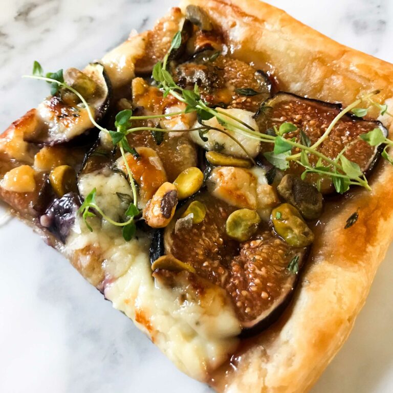a slice of the tart topped with a sprig of thyme.