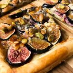 cooked fig, blue cheese tart on a cutting board.