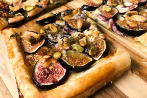 cooked fig, blue cheese tart on a cutting board.