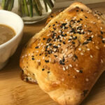 baked calzone with dipping sauce.