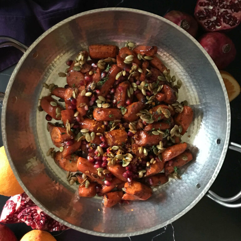 cooked glazed carrots with pepitas and pomegranate seeds.