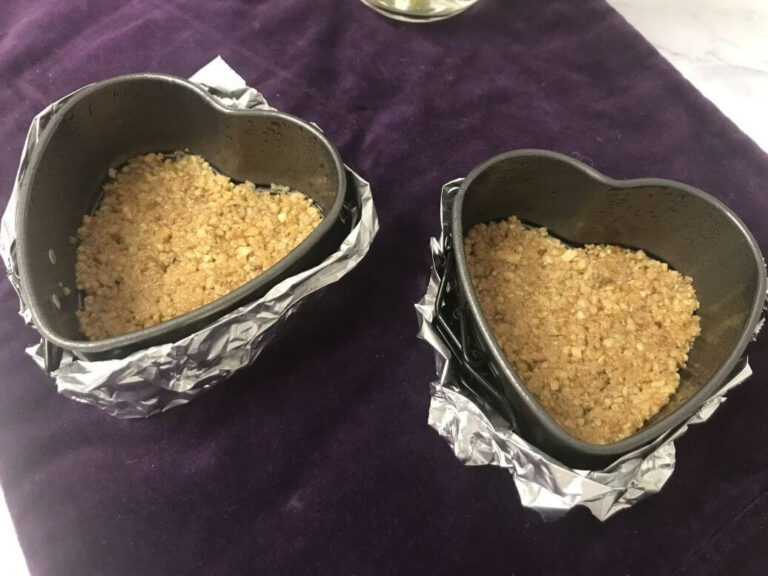 two heart shaped pans filled with crust.