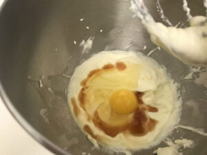 whipped cream cheese with egg and vanilla in a bowl.