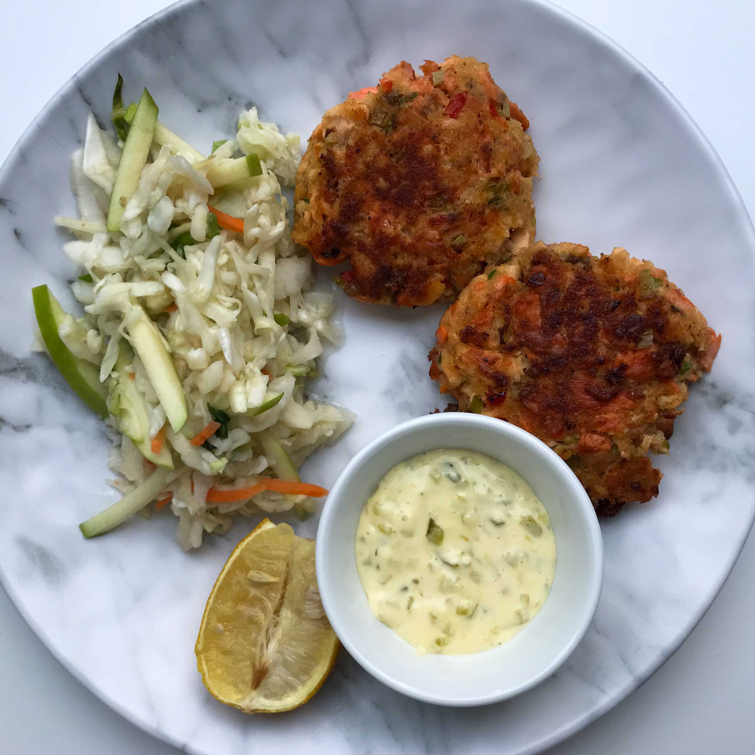 salmon patties and coleslaw on a plate.