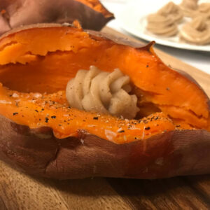 cooked sweet potato topped with a swirl of butter.