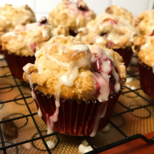 clementine glazed cranberry & walnut muffins on a rack.