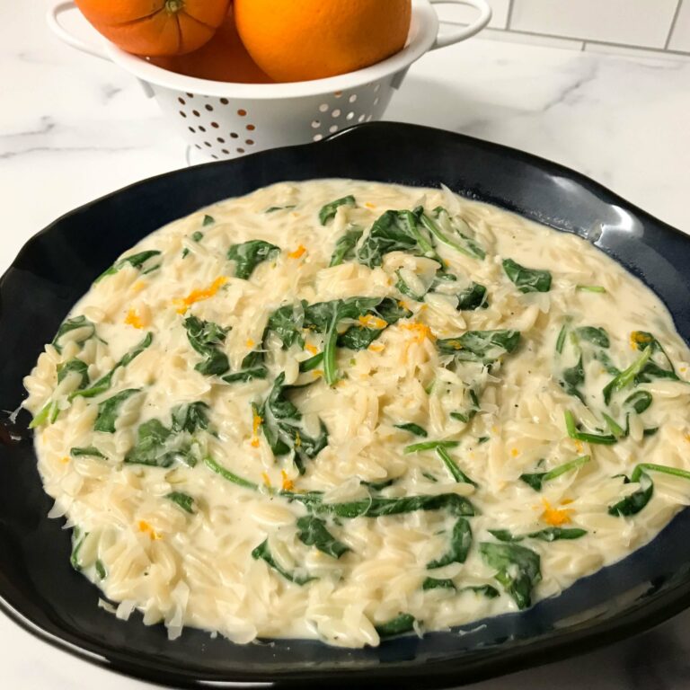 bowl or orzo with orange and spinach.