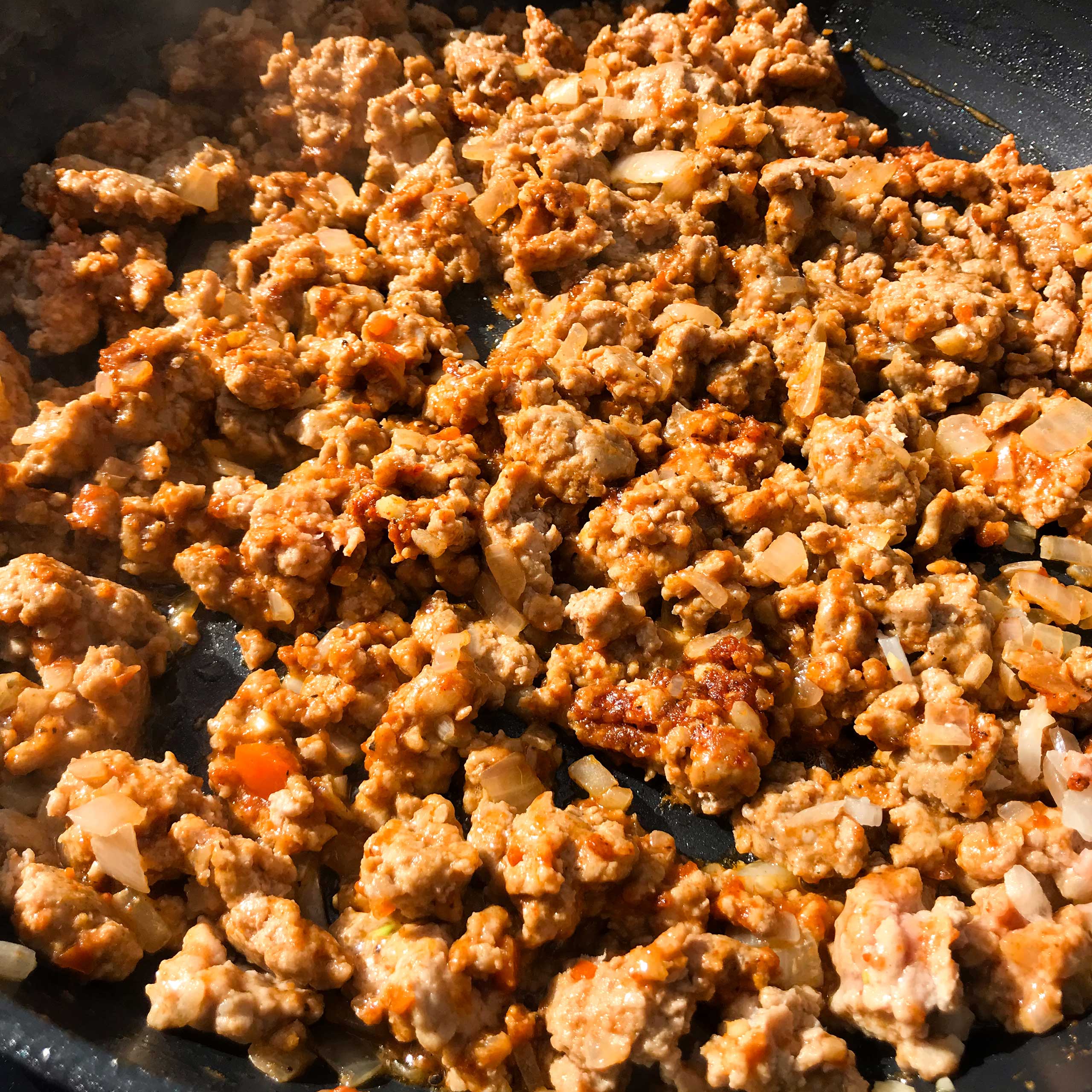ground meat cooking in skillet.