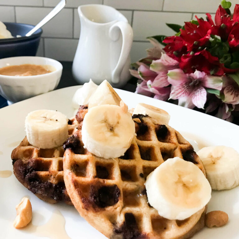 plate of waffles with bananas.