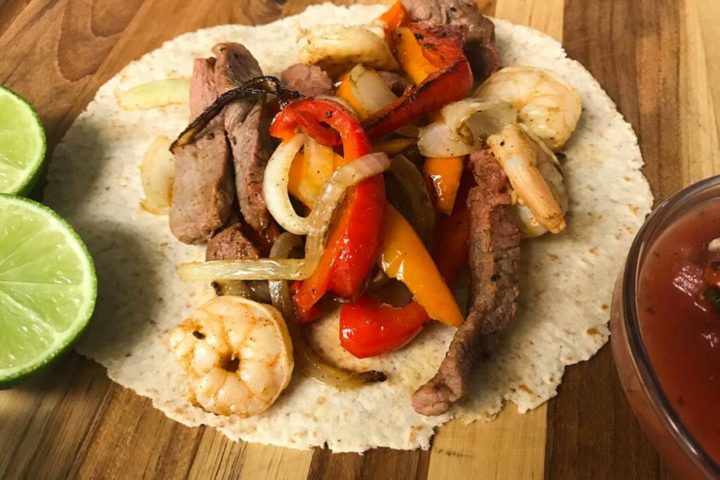 shrimp and steak fajita with limes.