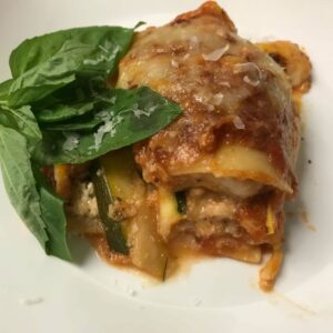 square of lasagna on a plate with basil.