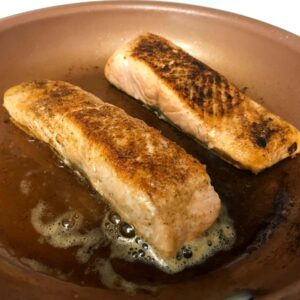 salmon cooking in skillet.