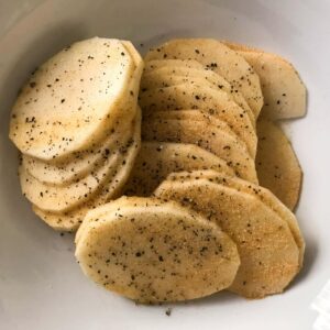 seasoned sliced potatoes in a bowl.