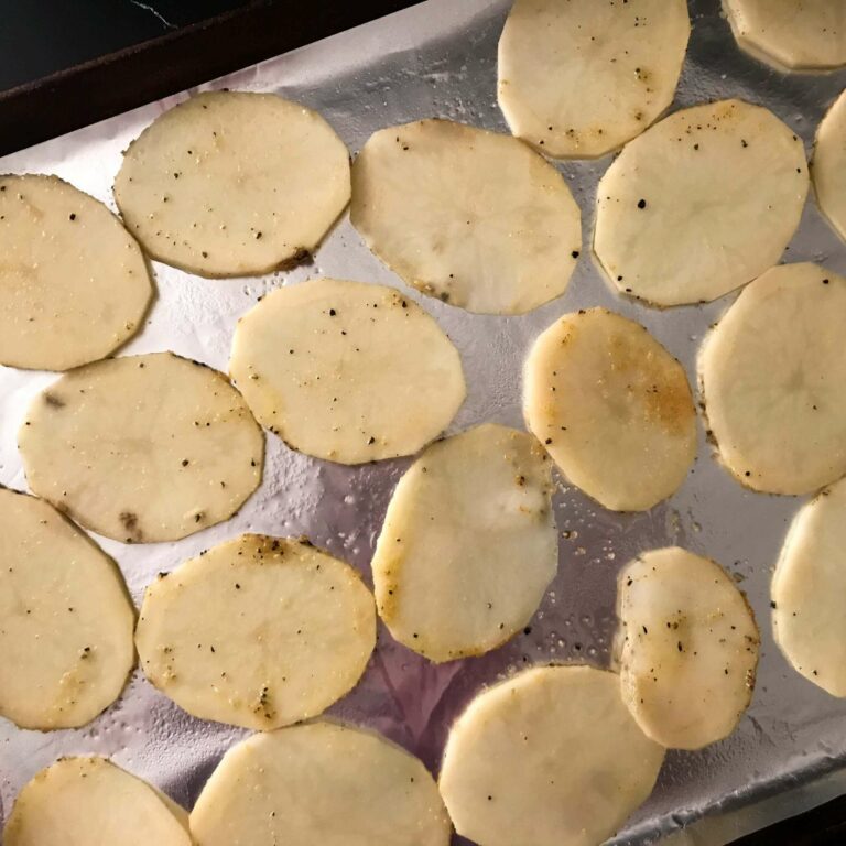 sliced potatoes on a baking sheet.