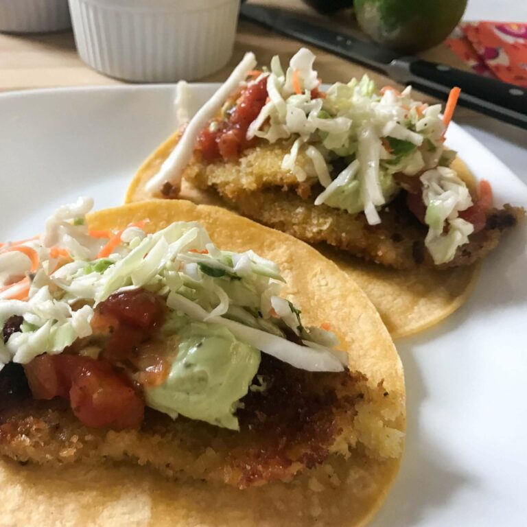 fish tacos with toppings on a plate.