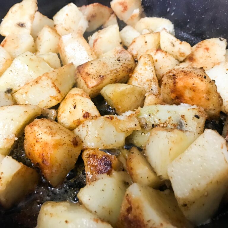 potatoes cooking in skillet.
