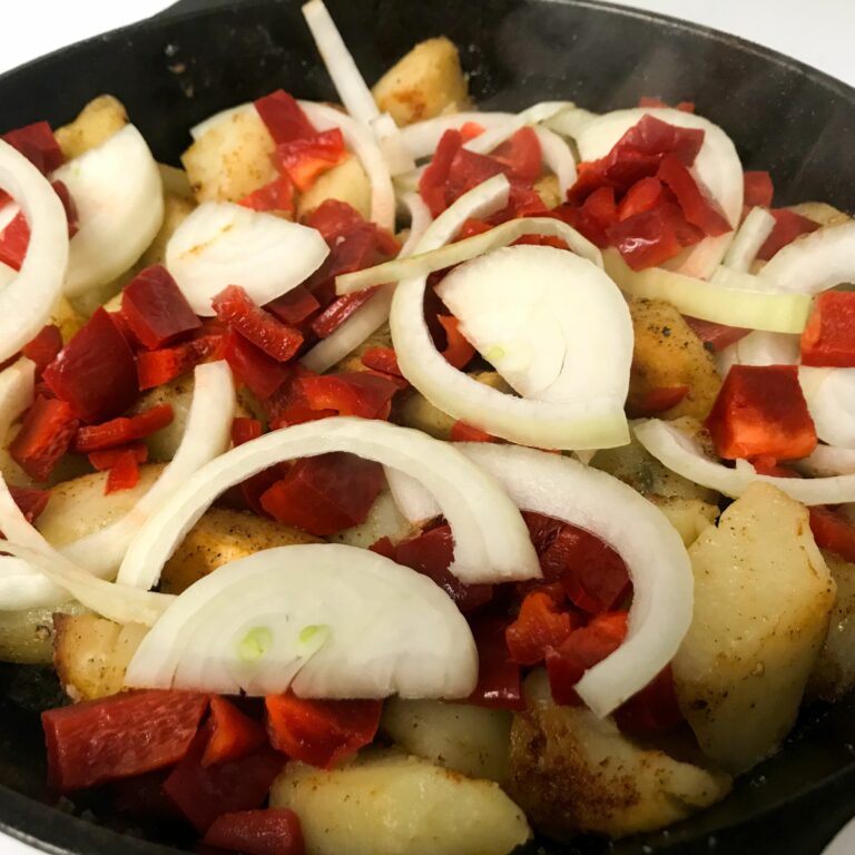 bell pepper and onions added to potatoes.