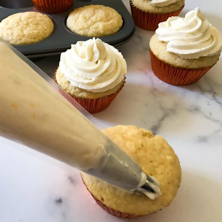 piping frosting on cupcakes.