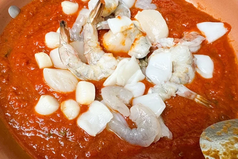 shellfish in a skillet with sauce.