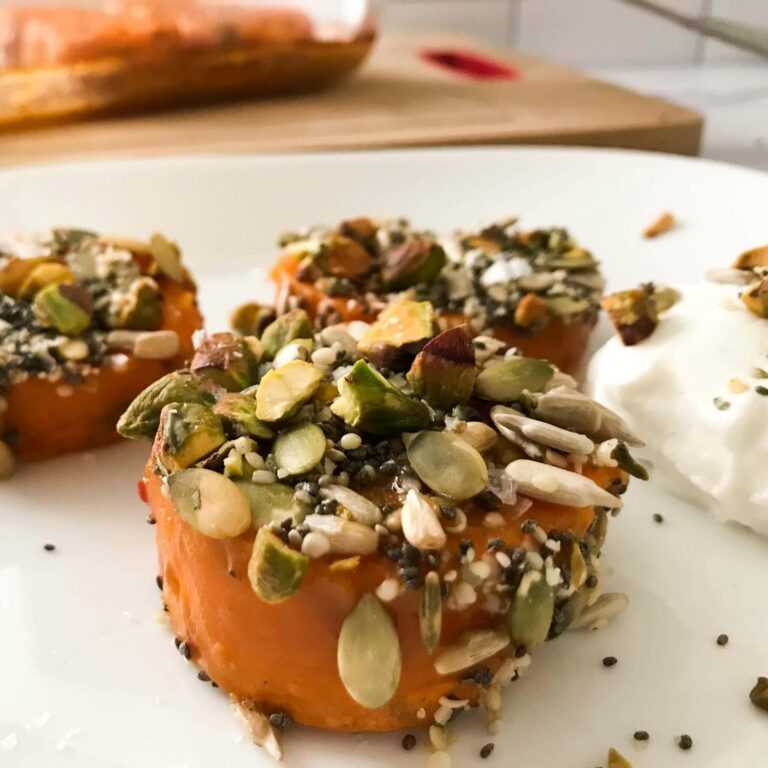 sweet potato rounds with seeds and nuts on a plate with yogurt.