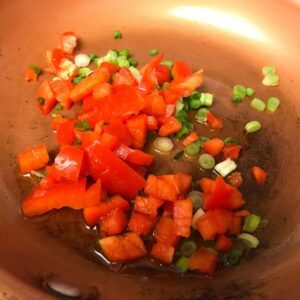 peppers and onions cooking in skillet.