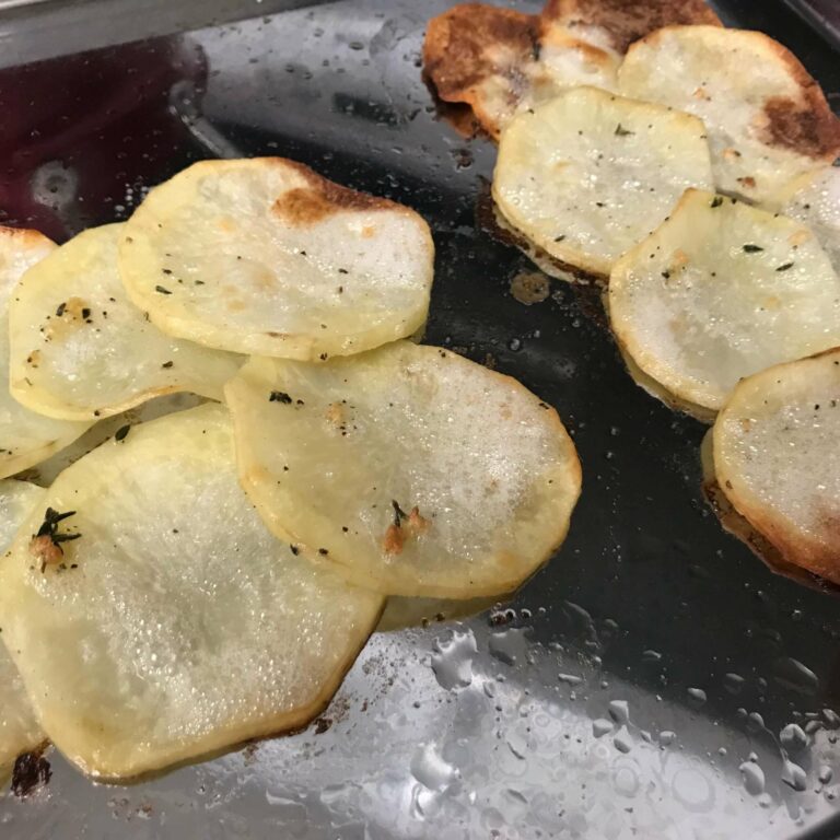 shingled potatoes on a baking sheet.