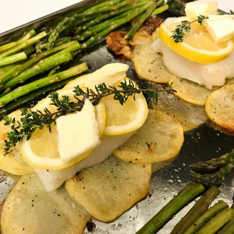 fish, potatoes and asparagus on a baking sheet.
