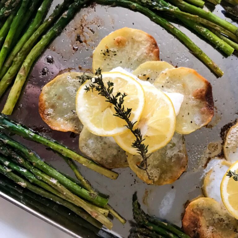 cooked fish on potatoes with asparagus.