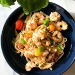 bowl of tagliatelle with shrimp, capers, lemon and heirloom cherry tomatoes.
