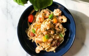 bowl of tagliatelle with shrimp, capers, lemon and heirloom cherry tomatoes.