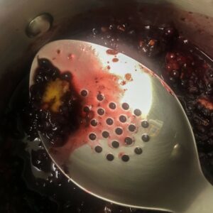 spoon in pot of blackberries.